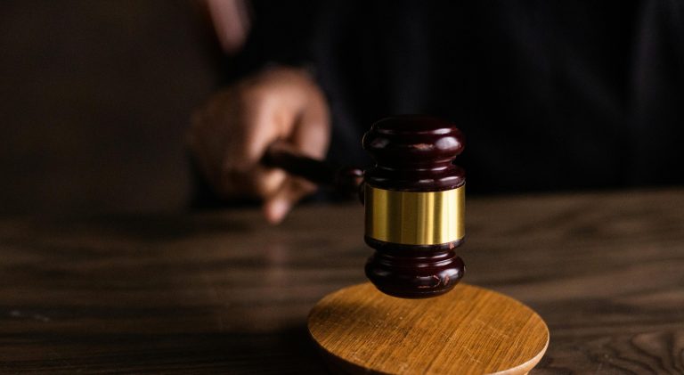 A gavel striking a sound block, symbolizing justice and legal authority in a courtroom setting.